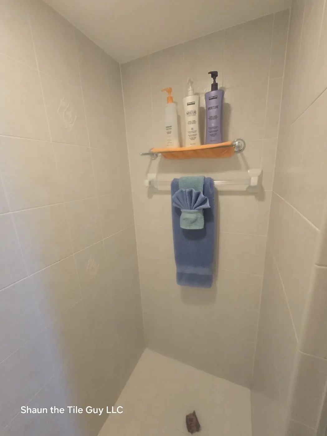 Dated beige tile shower before the remodel
