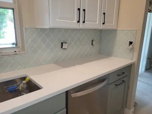 Arabesque glass backsplash in a white kitchen