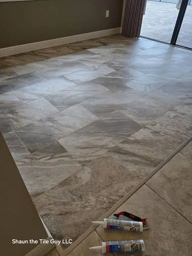 Marble-look porcelain floor transition with diagonal layout