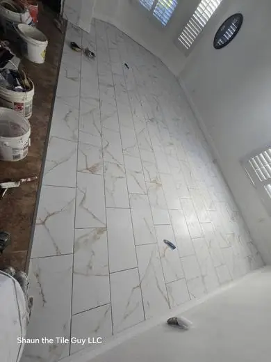White marble-look floor with gold veining being installed
