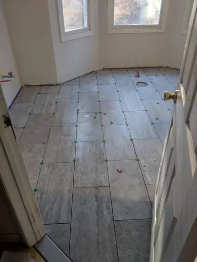 Large-format floor tile laid with spacers and leveling clips